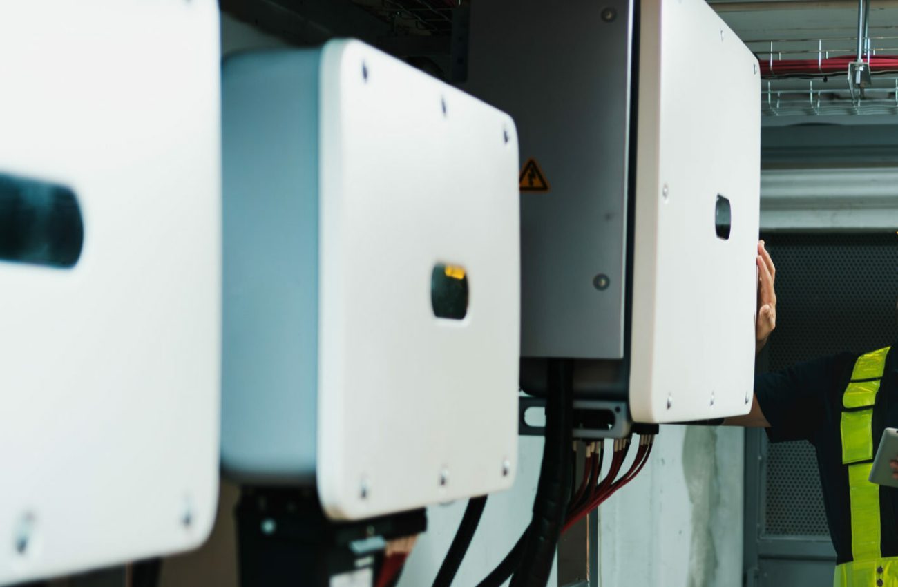Technician Engineering setting inverter solar panel in electrical room. Service engineer installing solar cell on the roof of factory. Clean and Renewable energy concept.